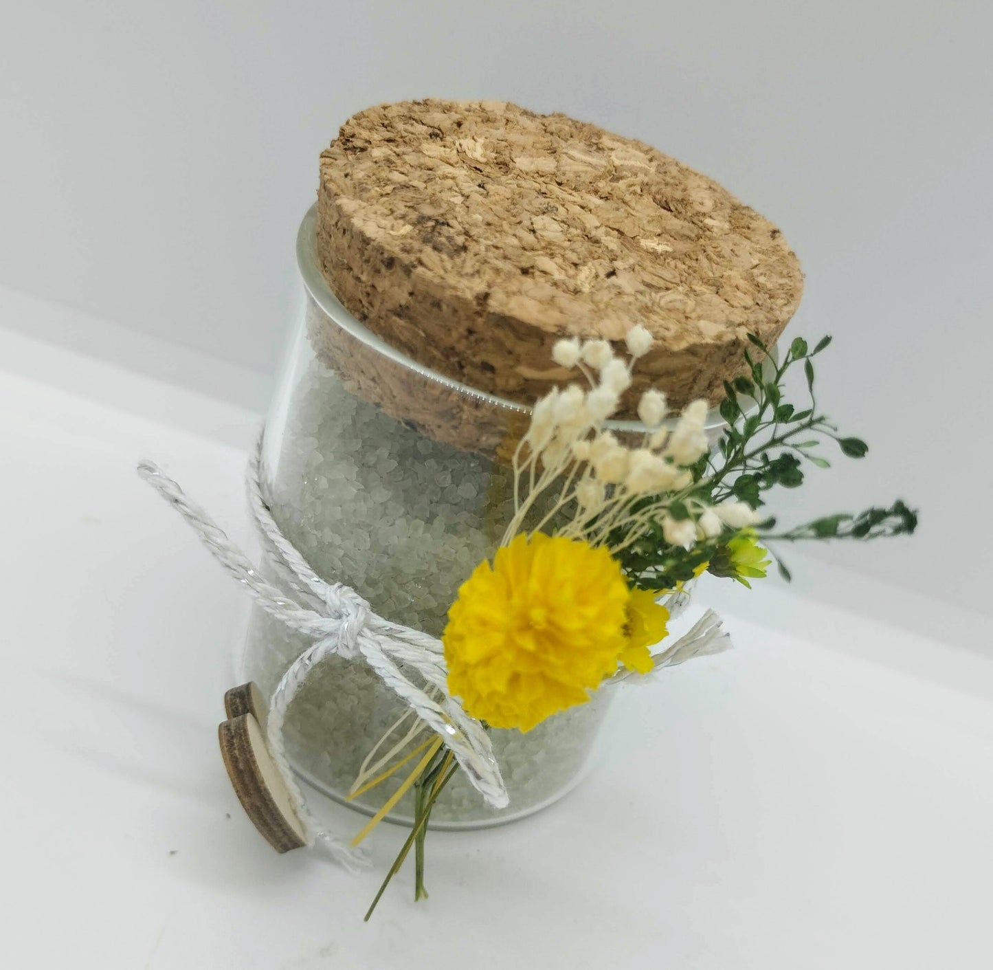 Glazen potje met scrubzout en droogbloemetjes